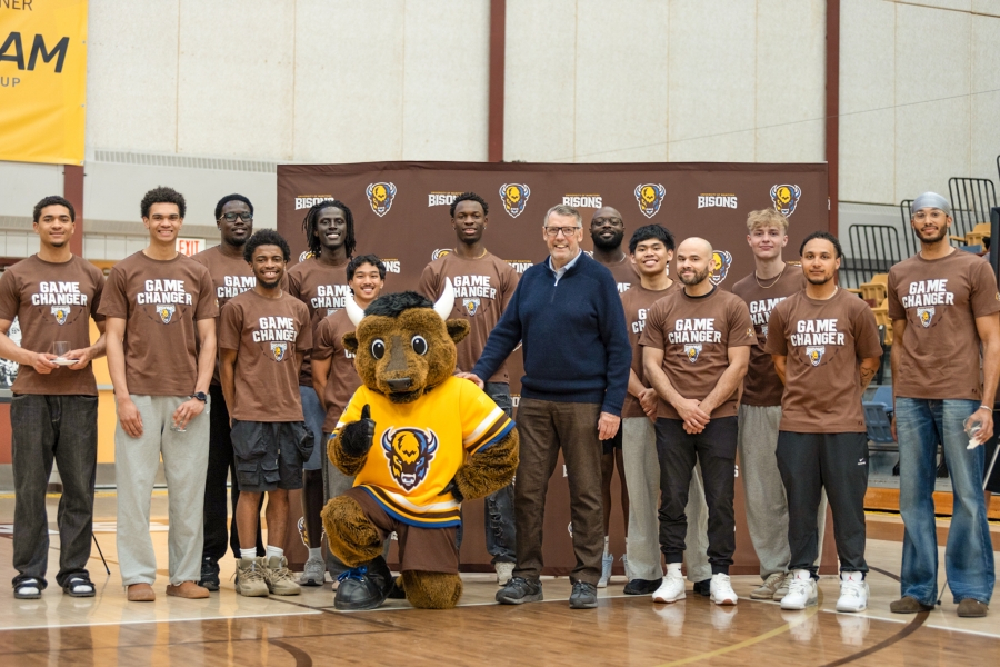 John Loewen with Billy the Bison and the men's basketball team