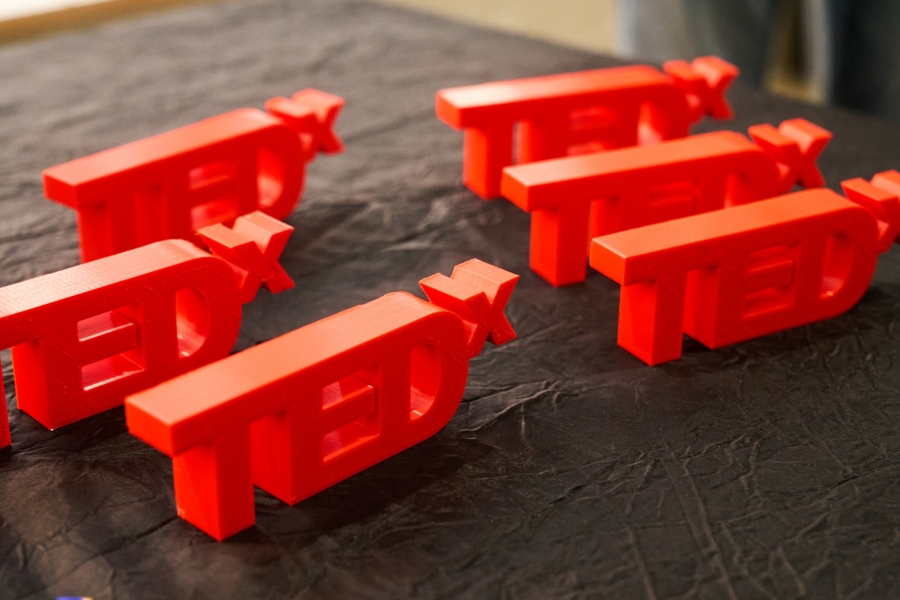 3D printed TEDx trinkets lined up on a table