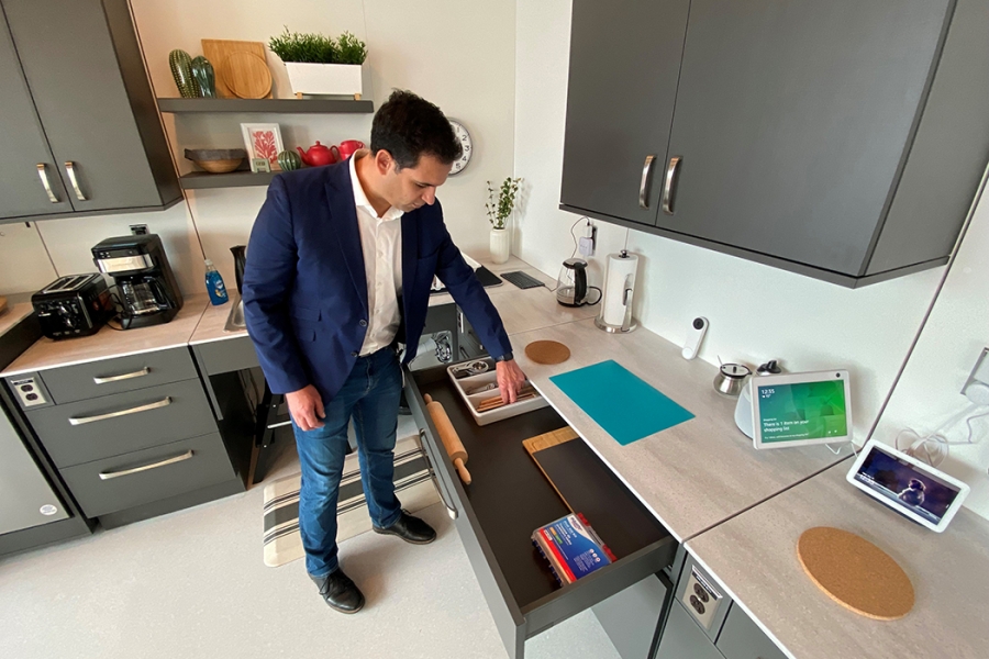 Dr. Amine Choukou looks into an open drawer in the smart suite kitchen.