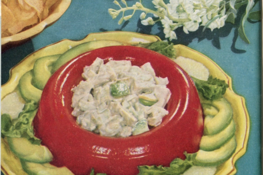 Close-up of colourful food plate of green cucumbers surrounding red aspic bowl holding salad.