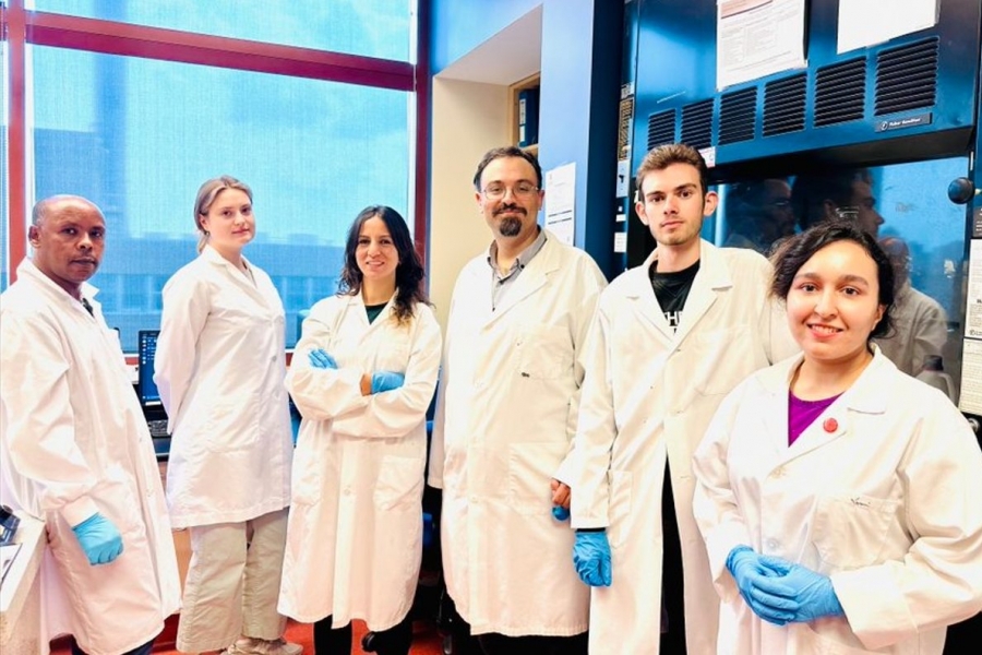 People wearing labs coats and gloves smiling in their lab.