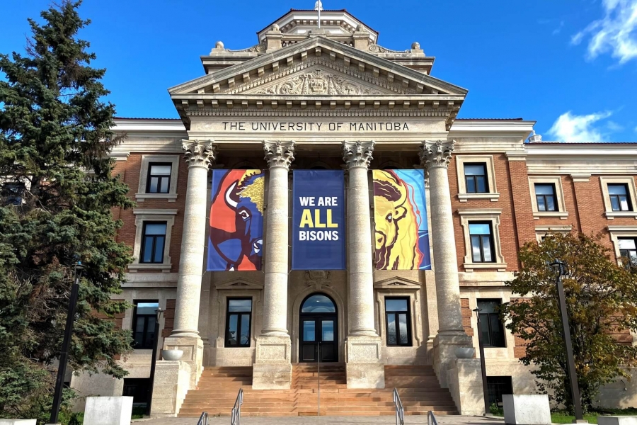 Three banners hang from the Administration Building, two with bison faces and the third with text stating "We are all bisons."