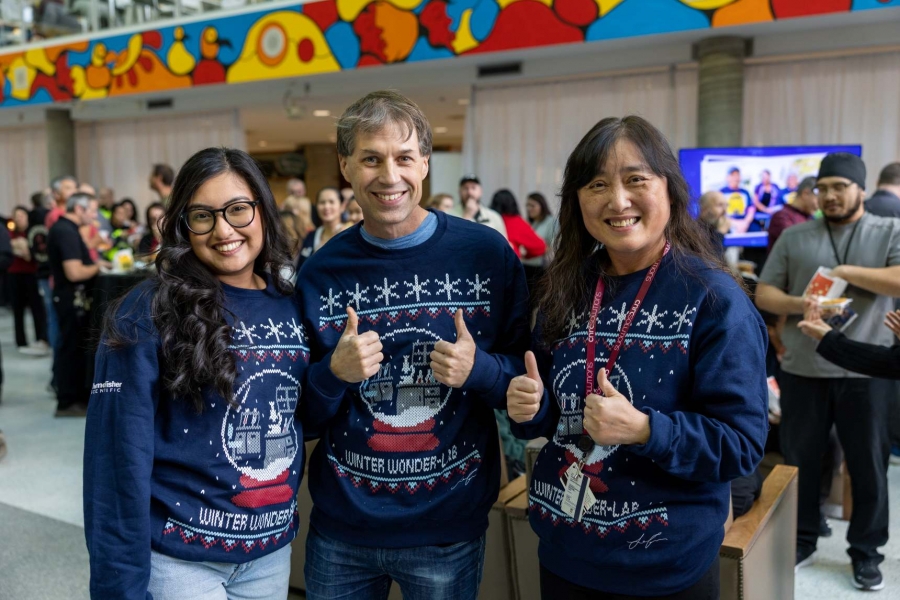 Three people standing together with smiles on their faces.