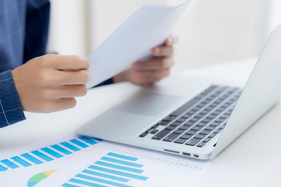 laptop and budget papers on top of a desk