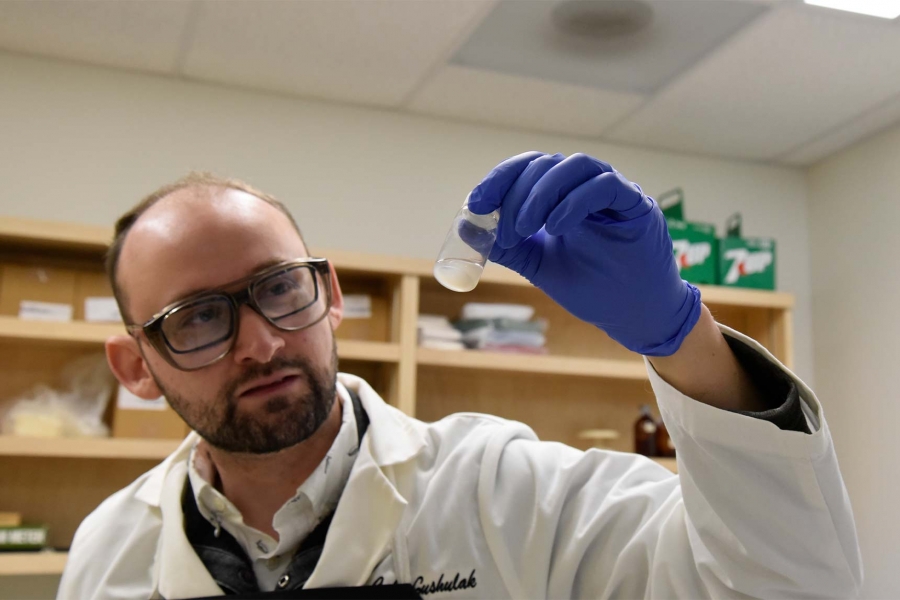 Cale Gushulak looking at a specimen.