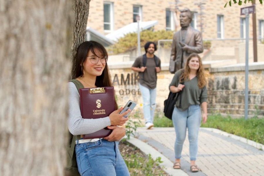 Three students walking outside of Migizi Agamik