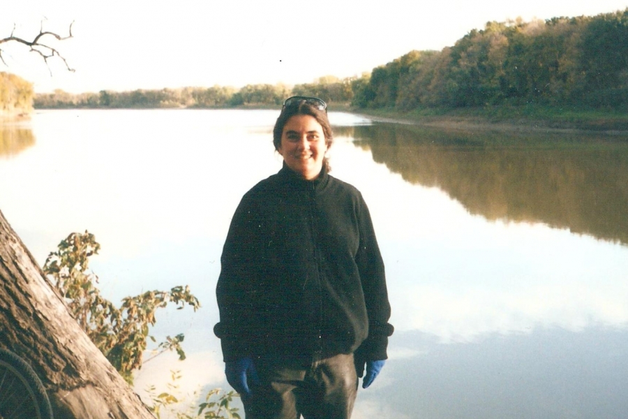 Dana Schroeder wearing a black jacket in front of a body of water and smiling at the camera.