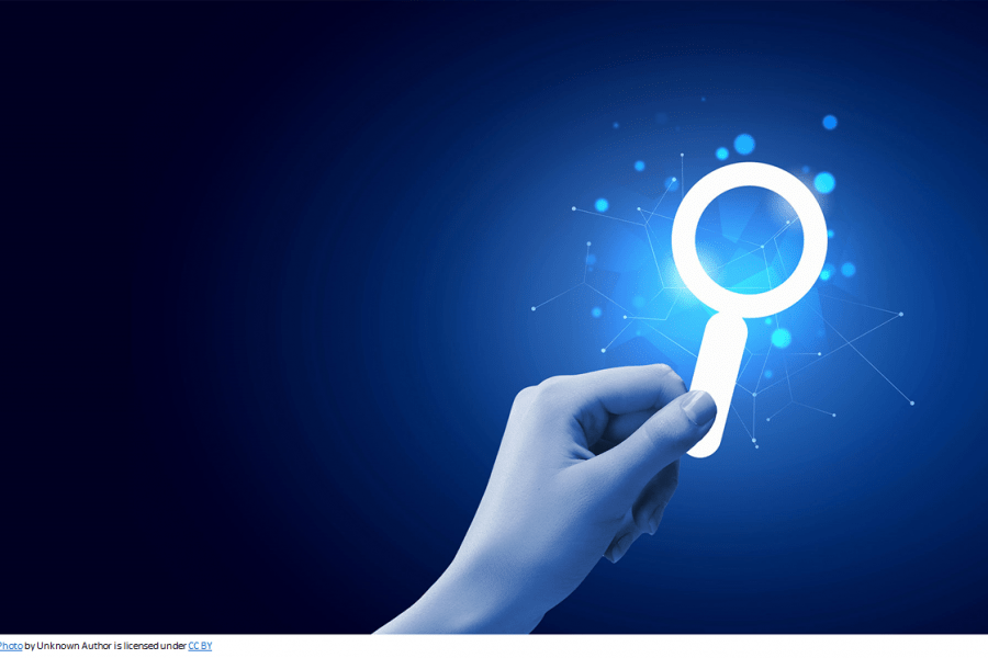 A hand searching online with a looking glass