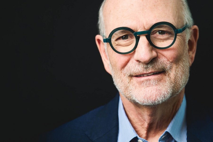 Harvey Chovinov, on a black background, looking at the camera