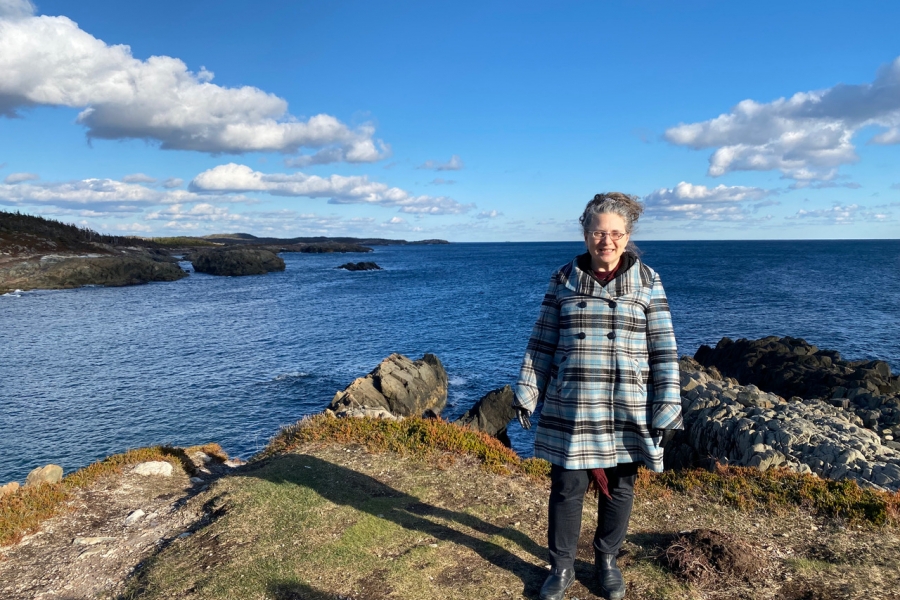 Jody Stark standing on rocks in front of a large body of water.