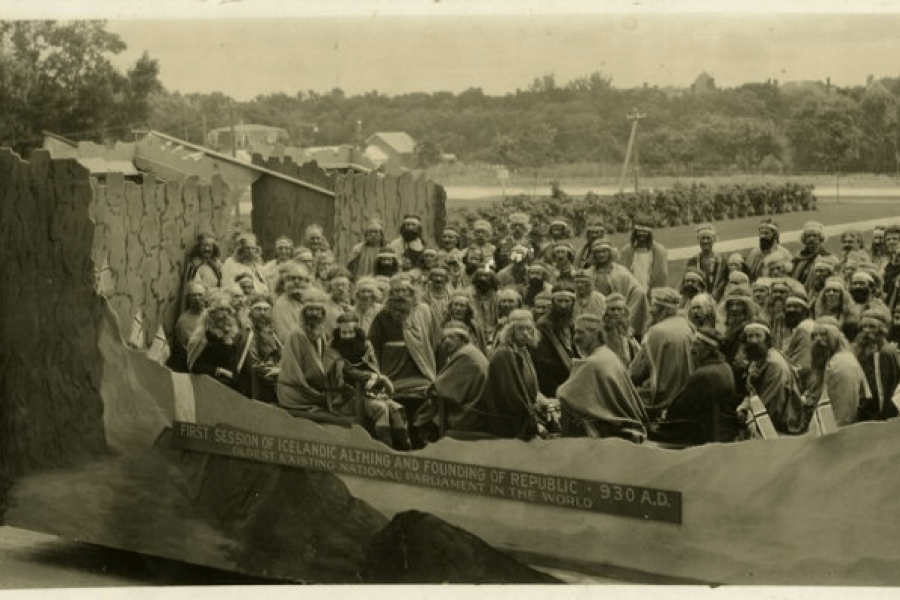 A bunch of people in a boat replica being pulled by horses