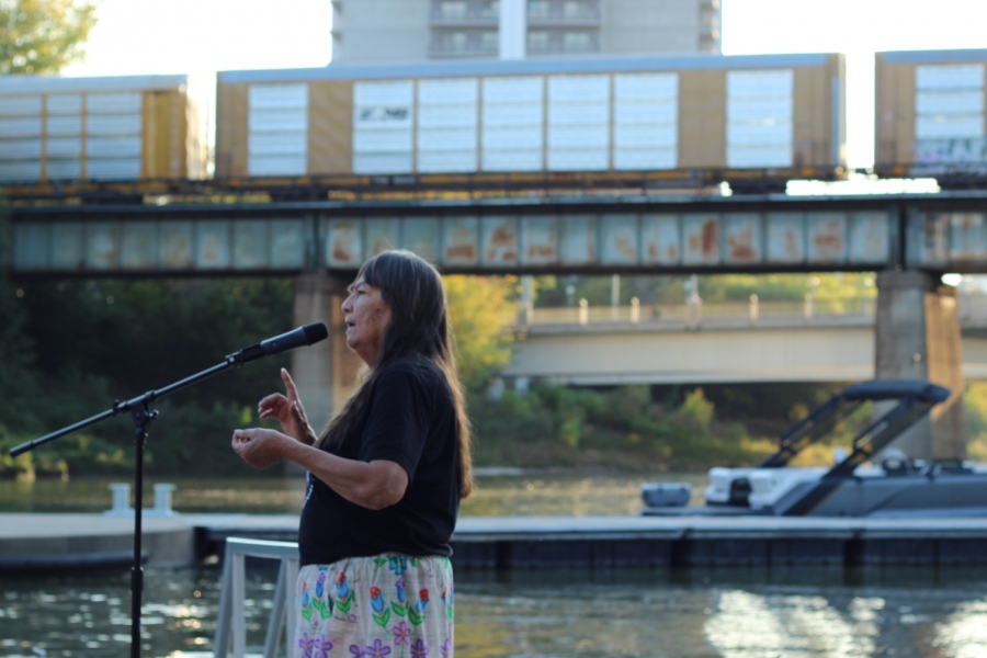 Dr. Kathy Bird standing in front of the Assiniboine River at The Forks.