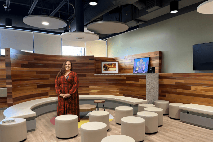 Person stands in circular seating area with Indigenous design elements