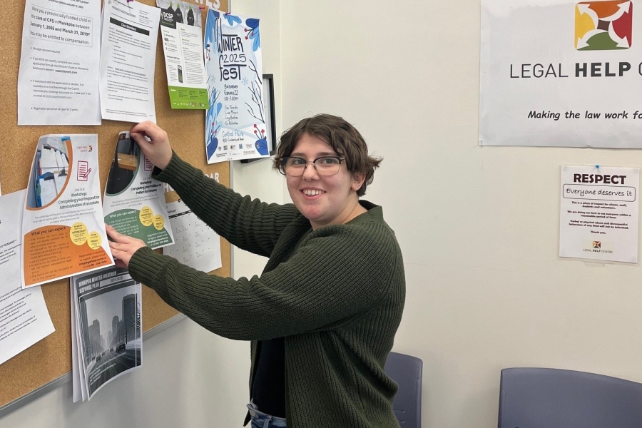 Monika Touzin posts on the bulletin board at the Legal Help Centre.