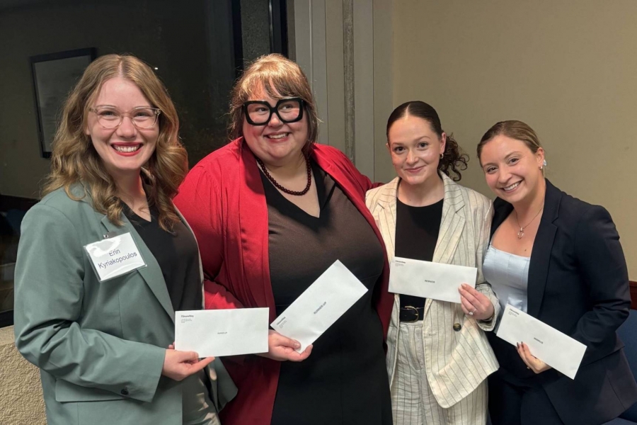 Four students smiling for a picture holding their awards. They are the two runners-up and the winning pair.