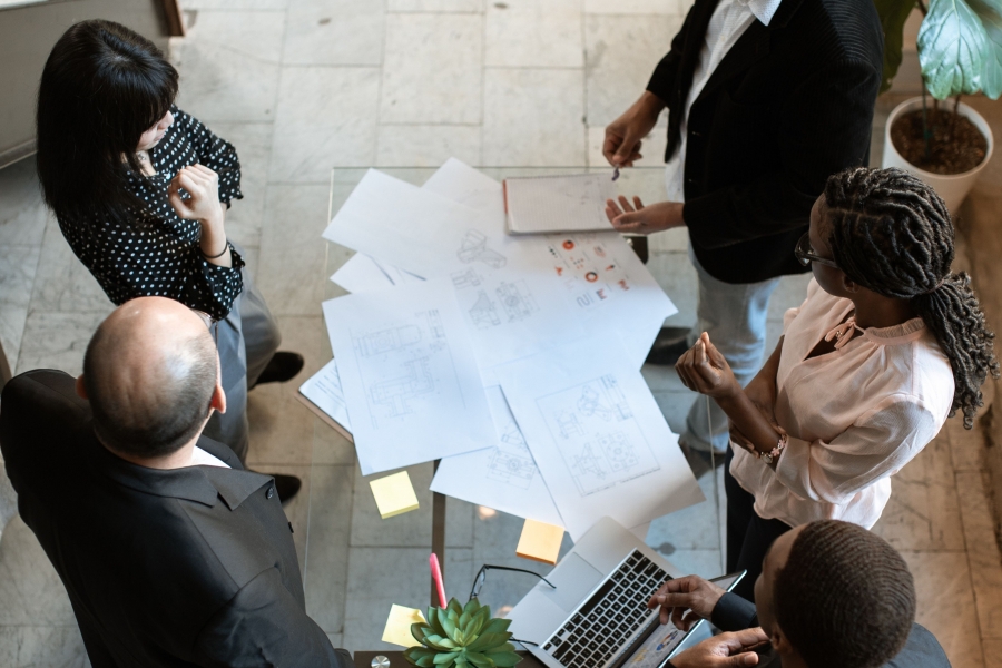 A business discussion happens over a table filled with papers