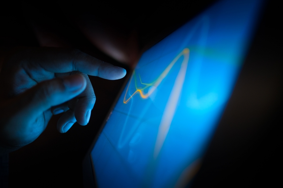 A finger touching a technology screen