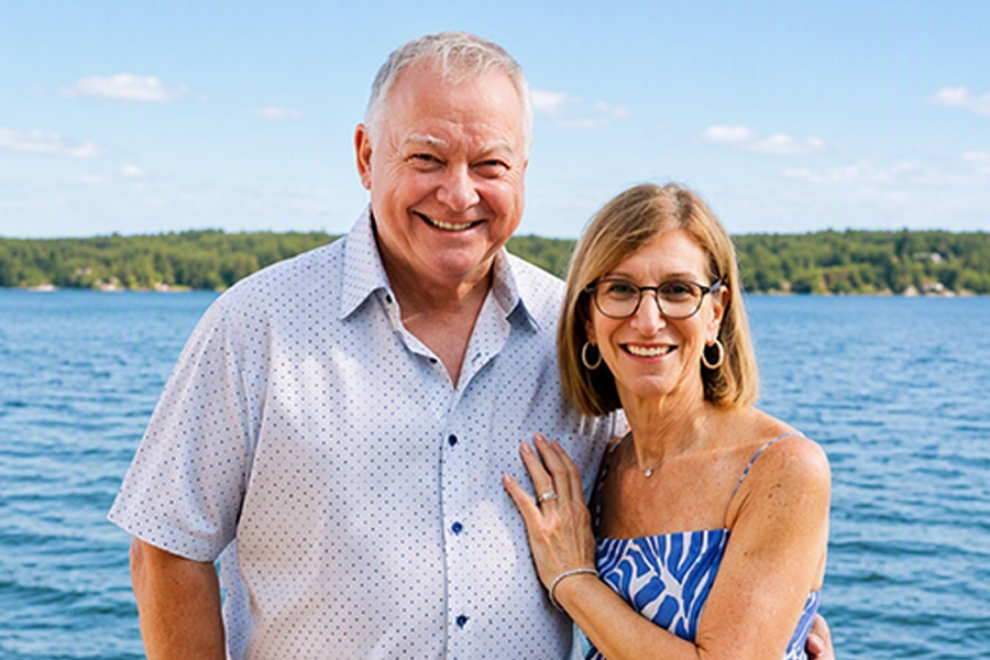 David and Joanne Provinciano standing on a dock with a lakeview in the background.