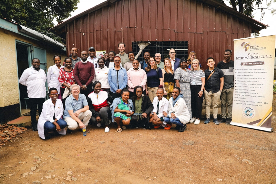 A group of smiling people outside of a building