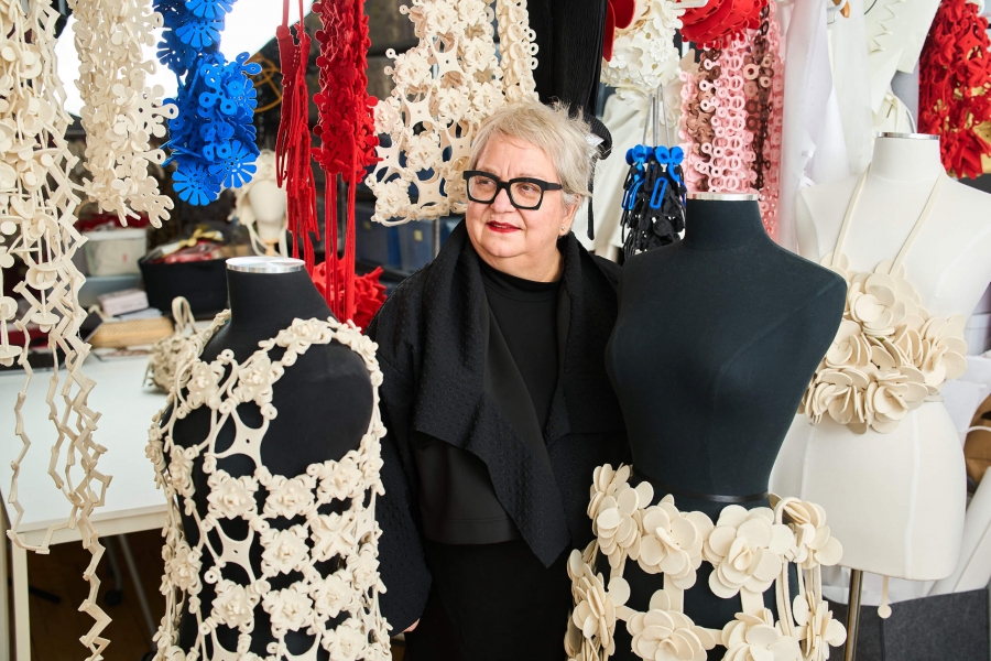 A woman standing in front of fashion designs