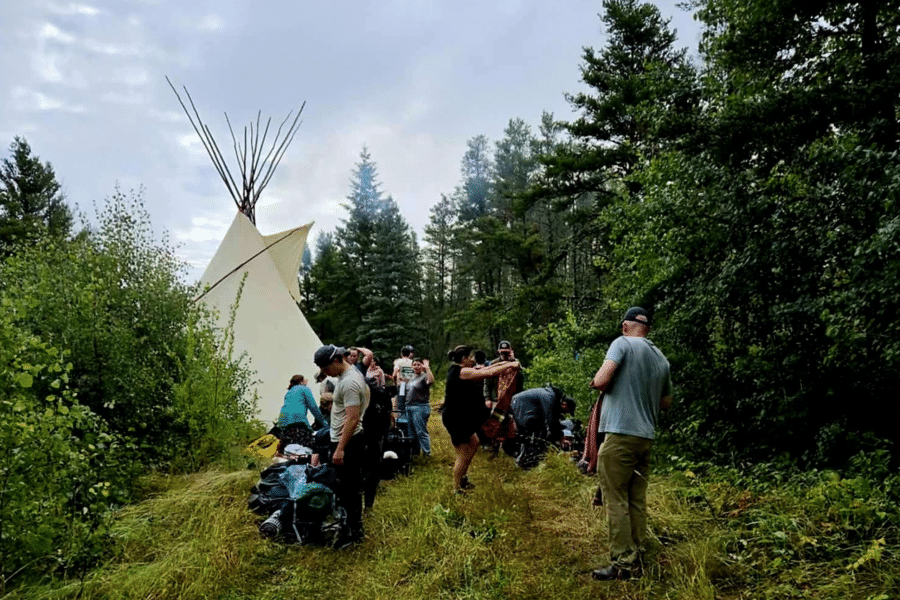 students exploring the Land with tipi in background