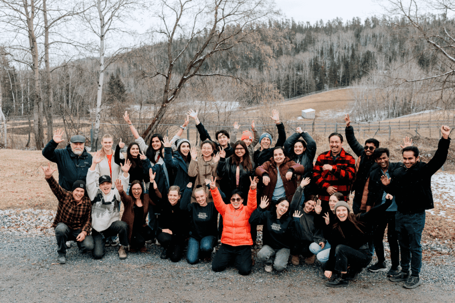 5. Participants pose together outdoors during a community gathering and learning retreat.