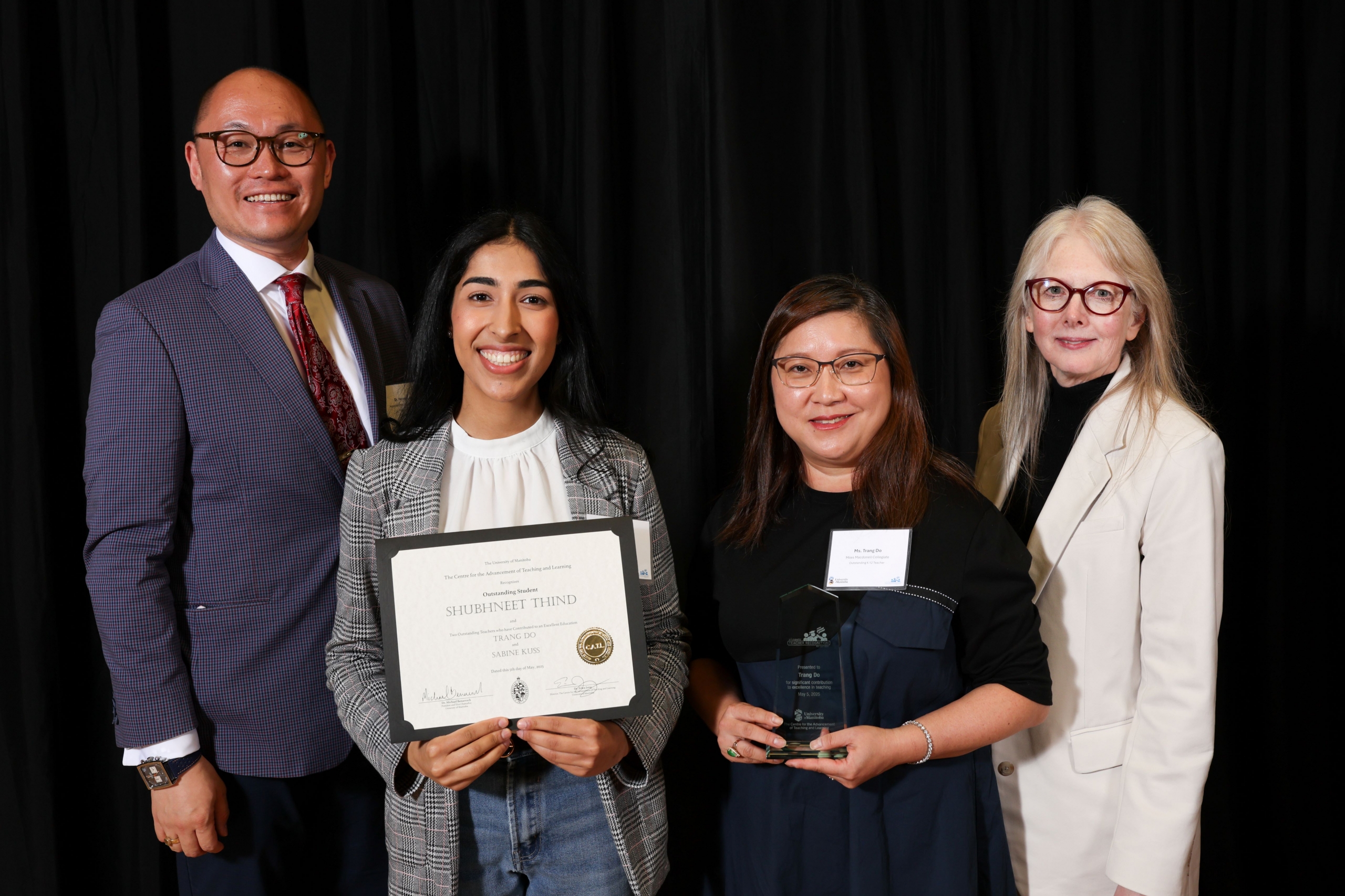 A graduating student poses with her award and other members from the ceremony.