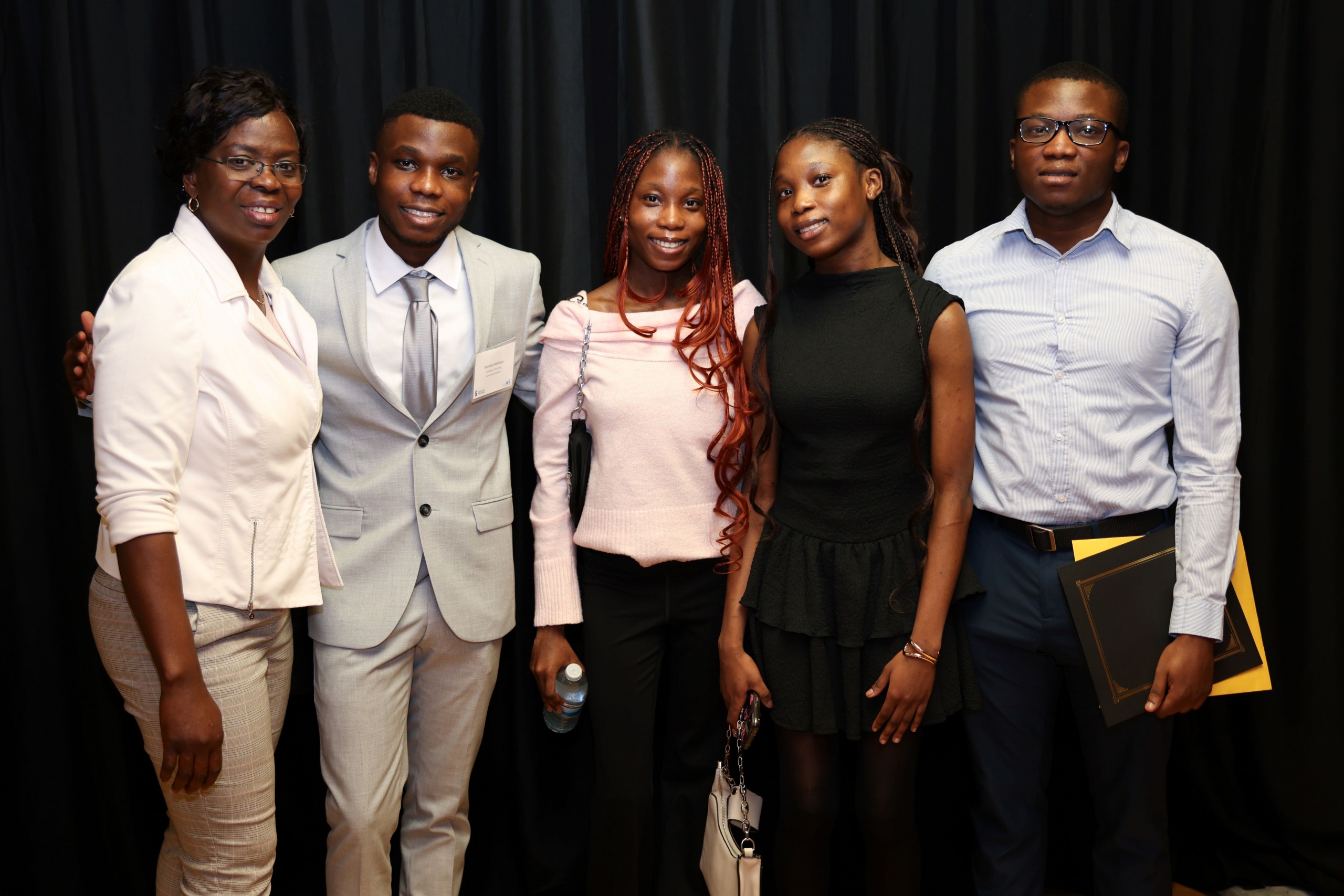 A family is posing for a photo to celebrate the award recipient.