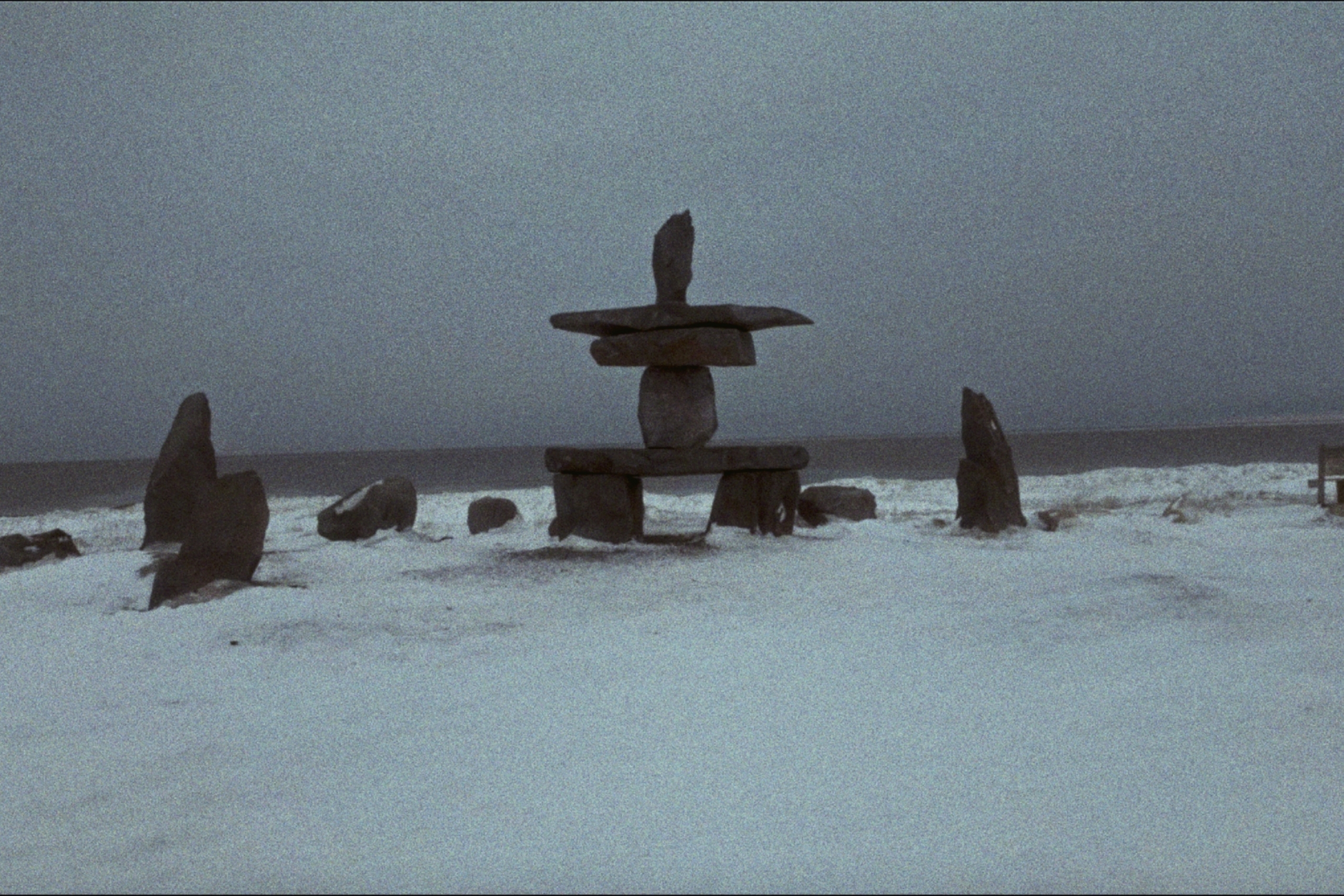 Giant Inukshuk at the easternmost point of Hudson Bay in Churchill, Manitoba. The sky is gray as it is 3 am in the fall.