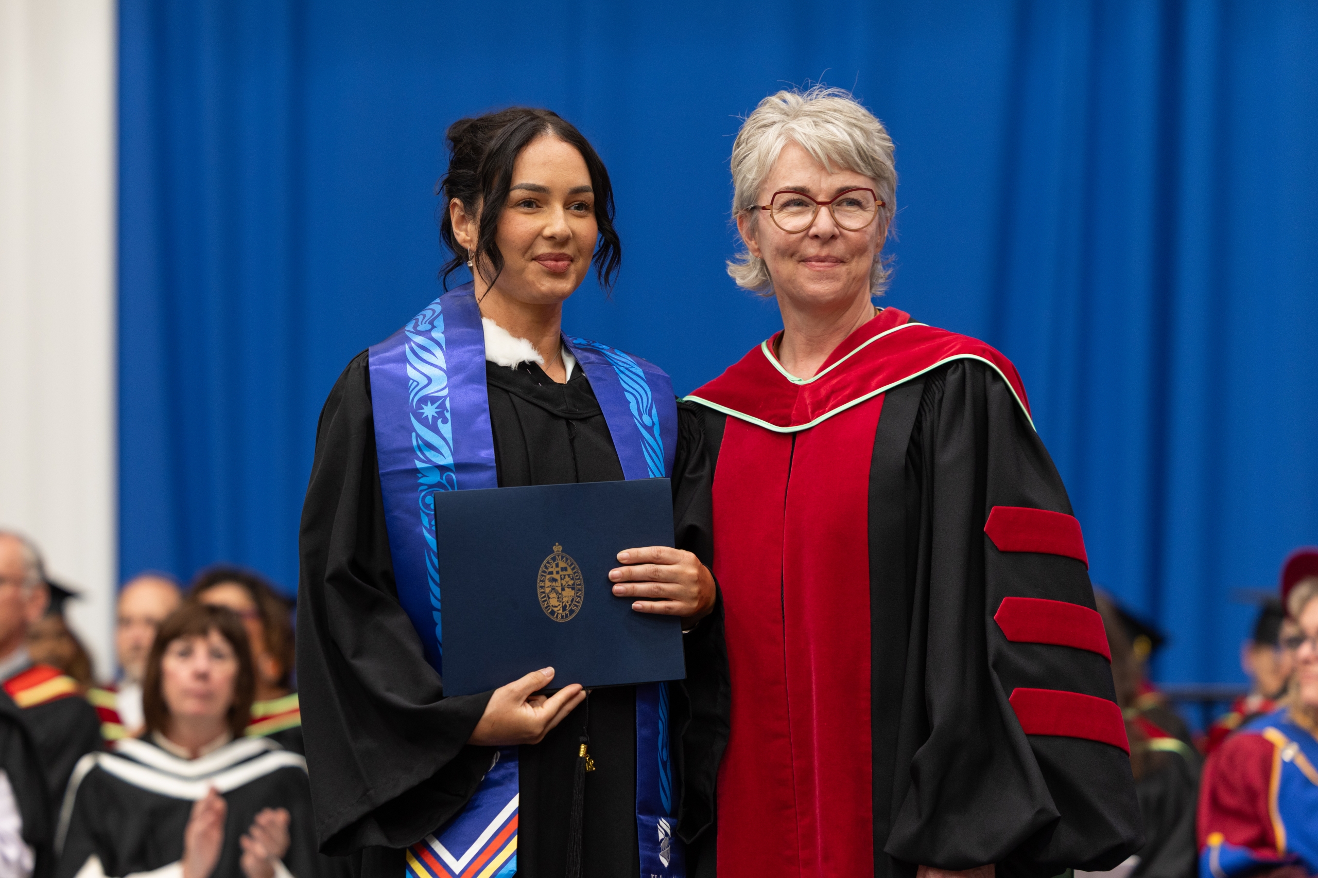 Courtney Chartrand on the convocation stage with Dr. Kellie Thiessen.
