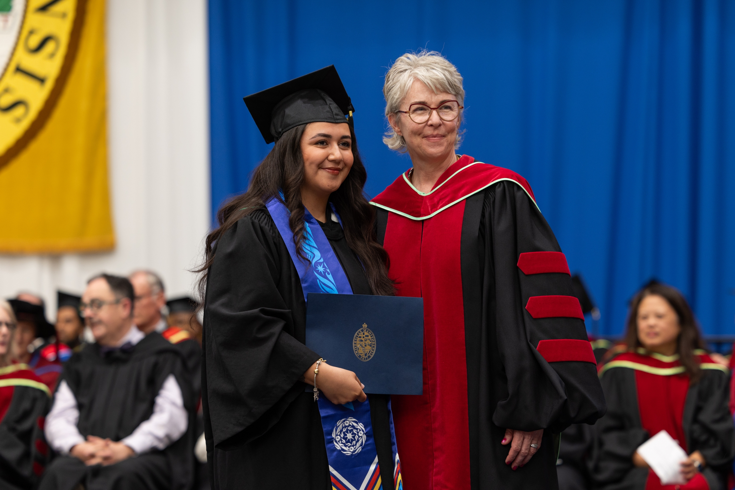 Kaydence Morgado Thomas with Dr. Kellie Thiessen on the convocation stage. 