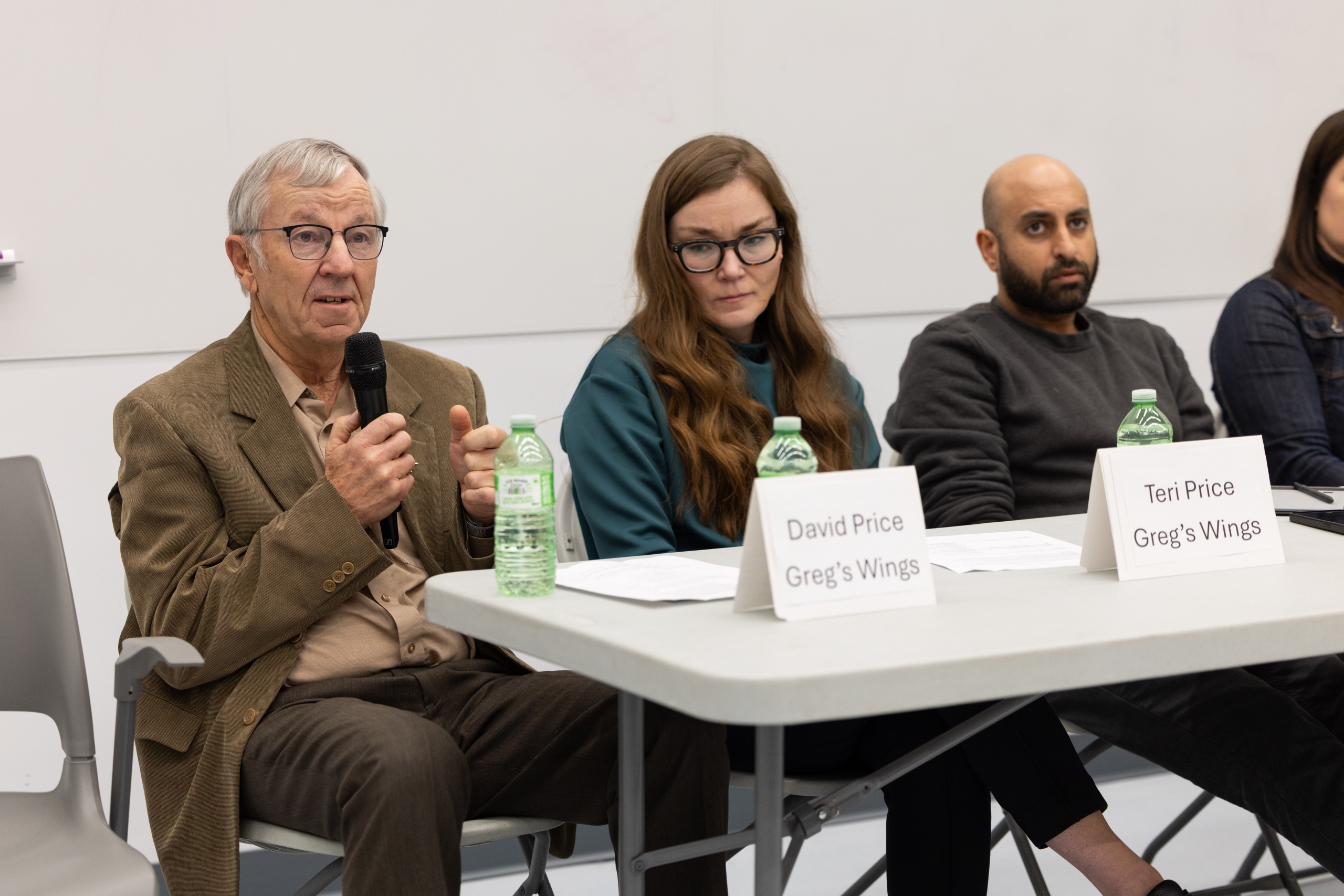 Dave and Teri Price sit next to physician Rafiq Andani at a table for a panel diiscussion.
