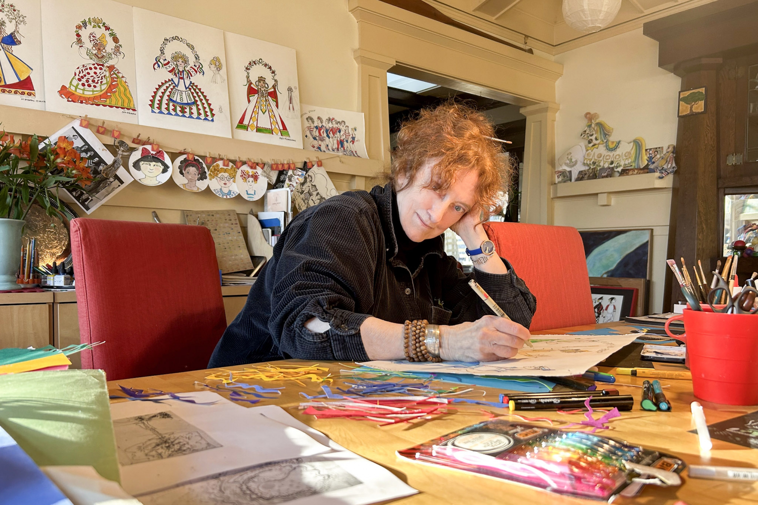 A woman looking at the camera while drawing