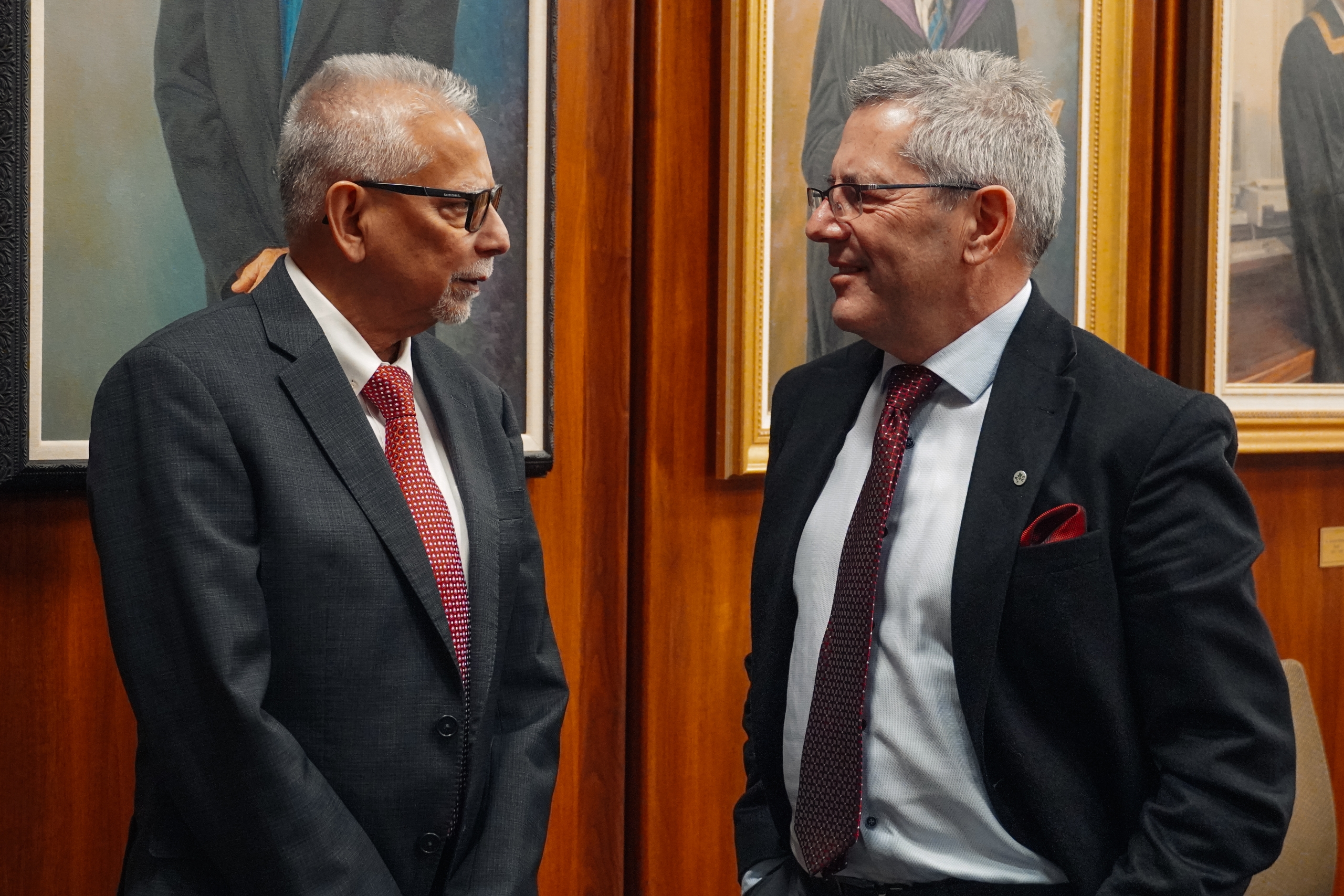 Two men in conversation, standing and facing each other