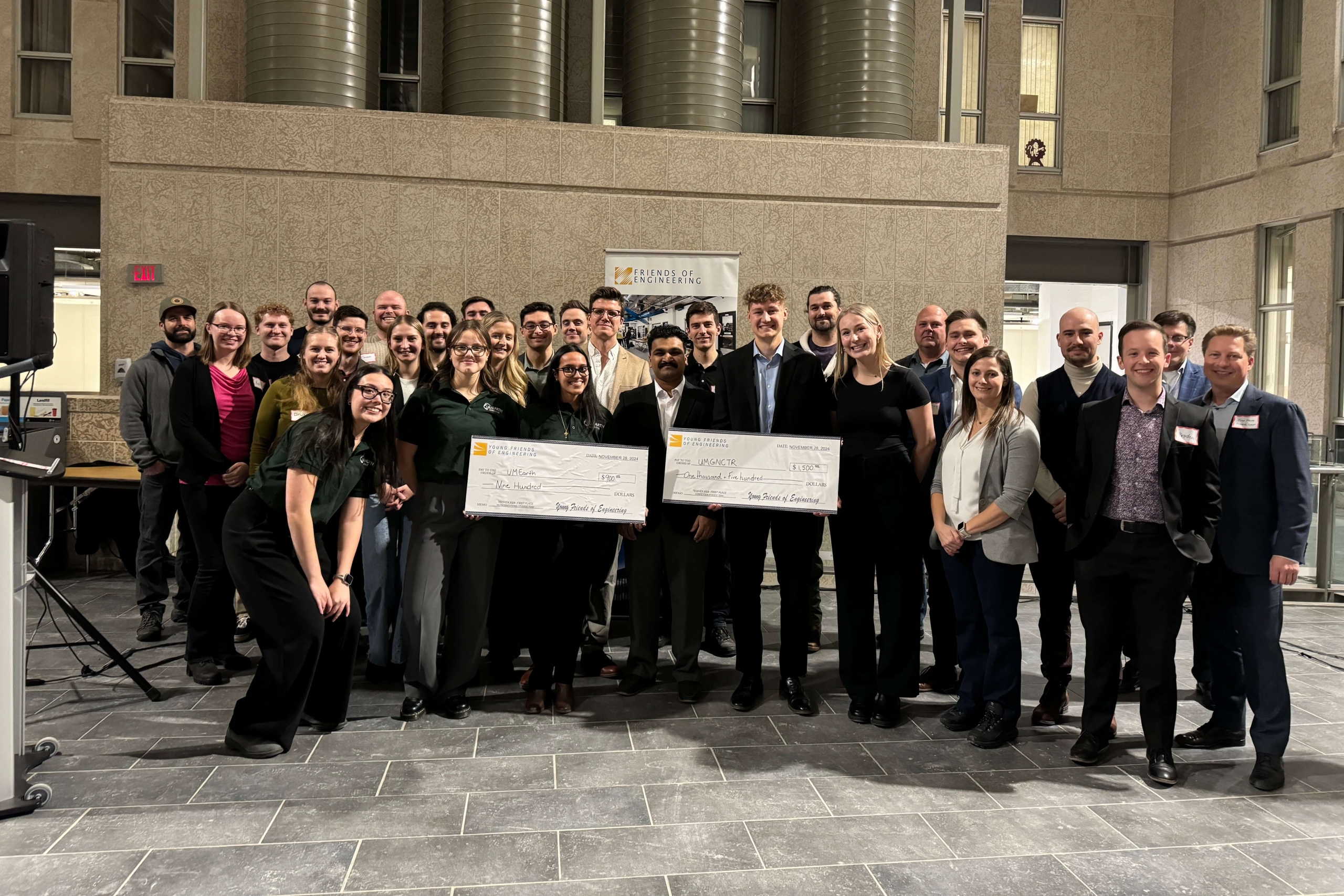 A group of students holding a novelty cheque