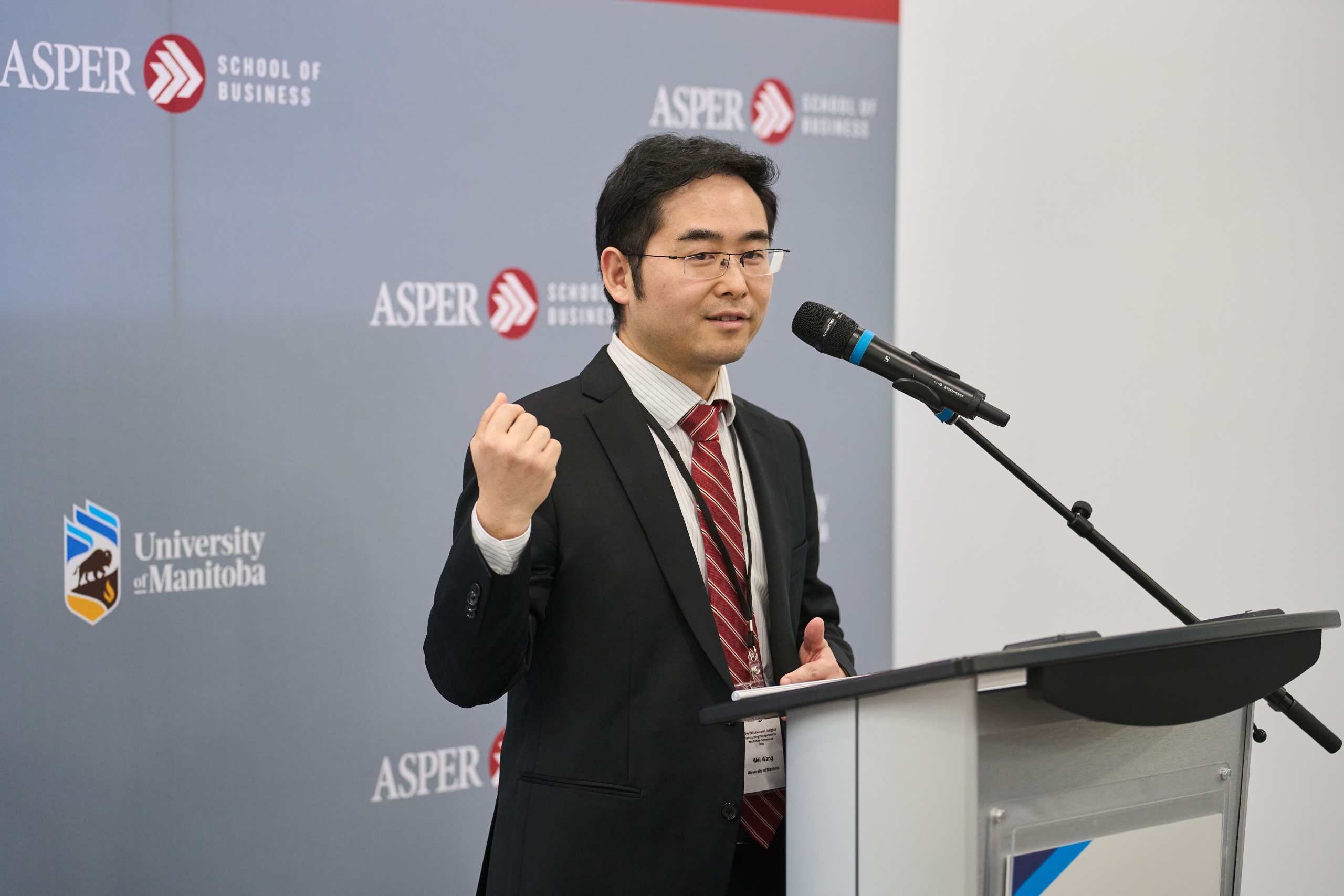 Wei Wang speaks at a podium