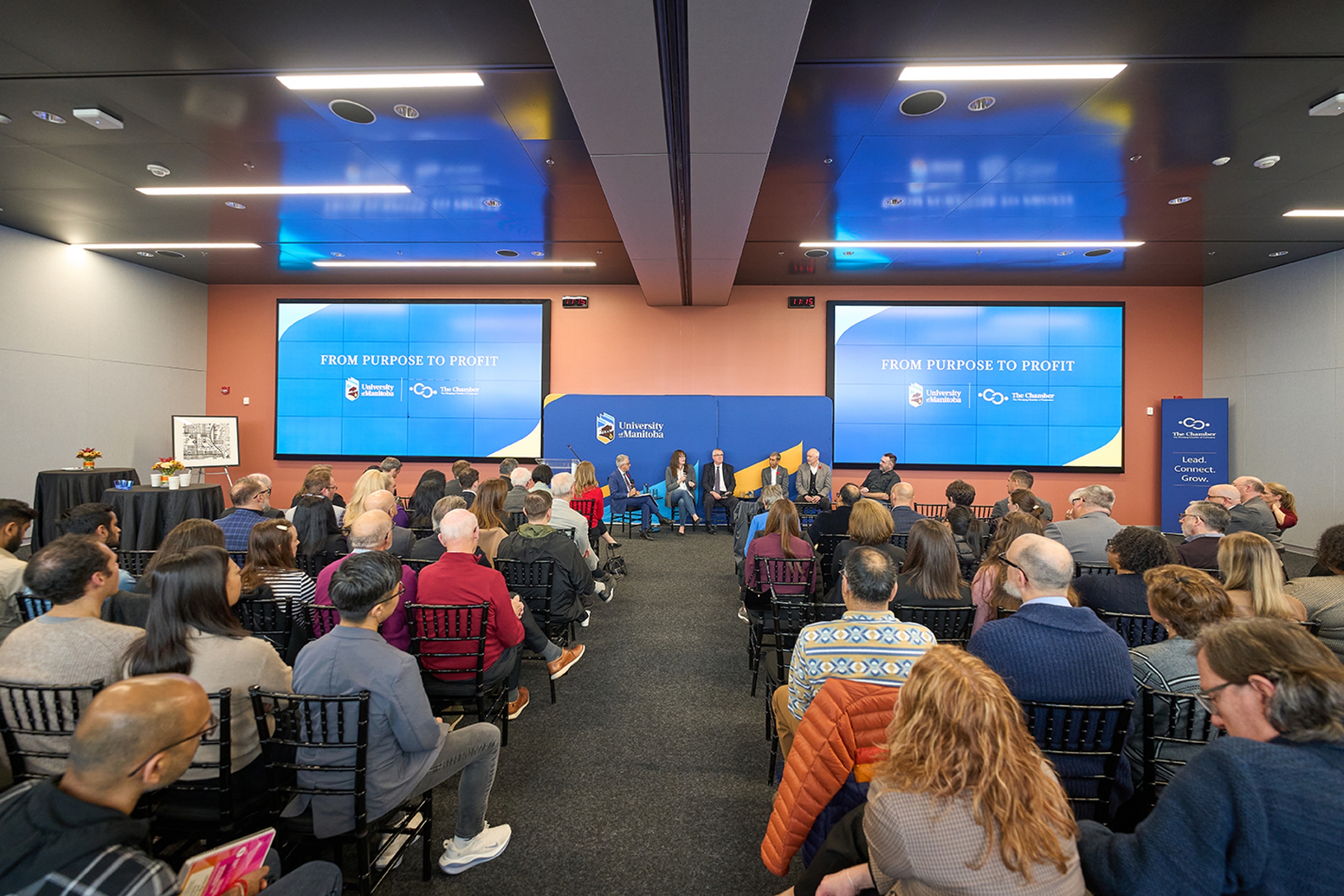 A group of people watching a panel presentation