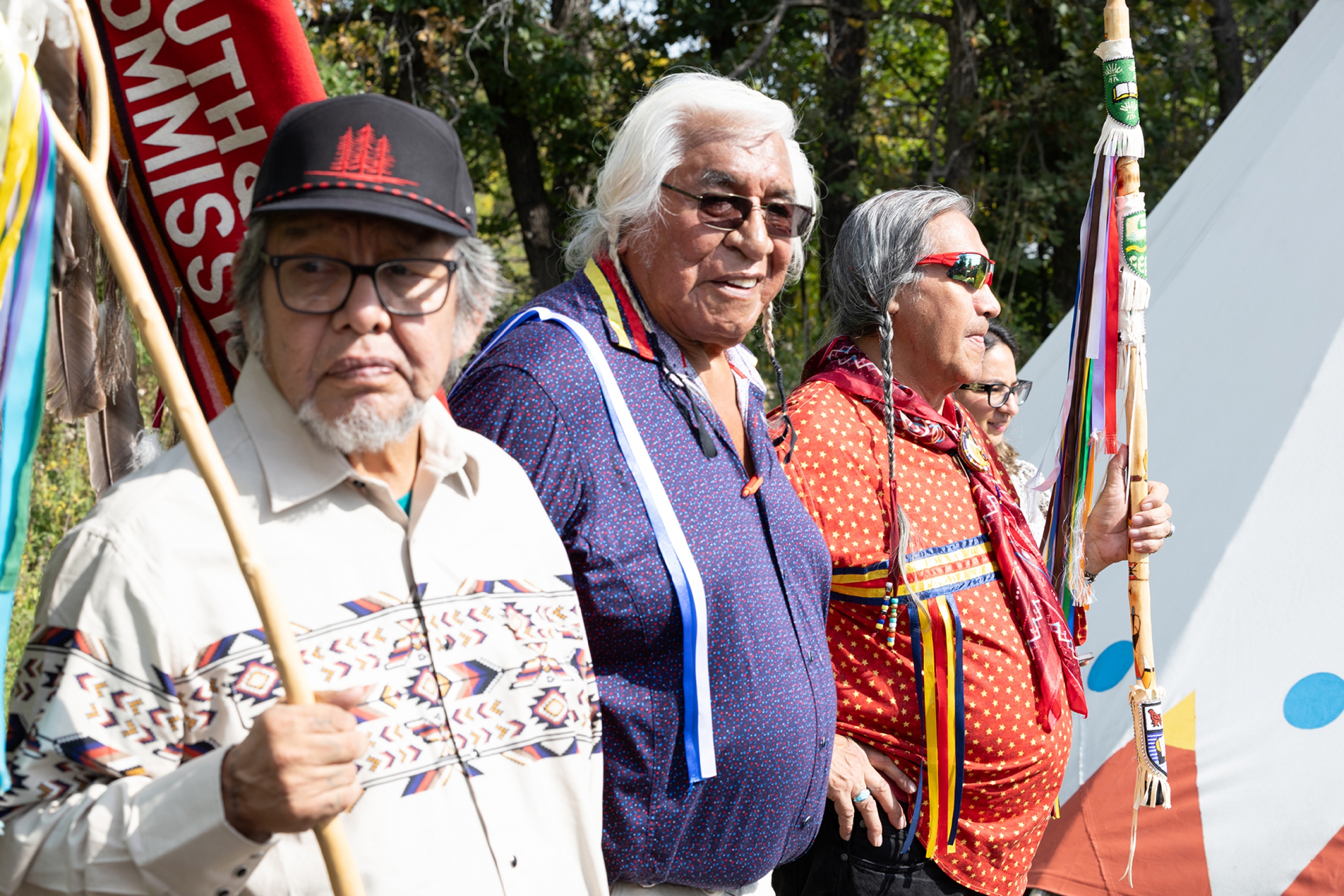 Elders and Survivors holding flags