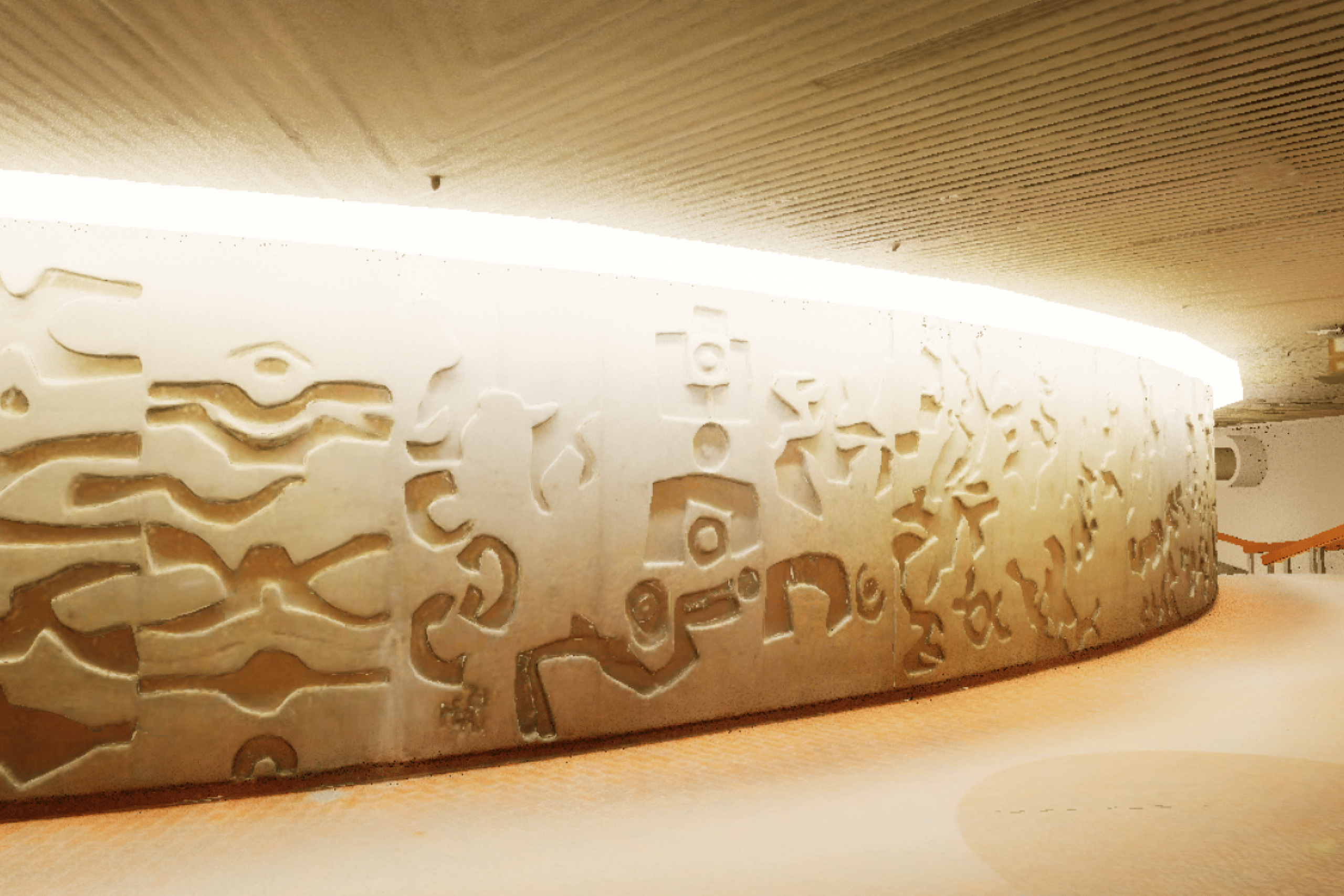 A curved wall with abstract carvings lit by overhead lights, creating a warm, inviting atmosphere. 