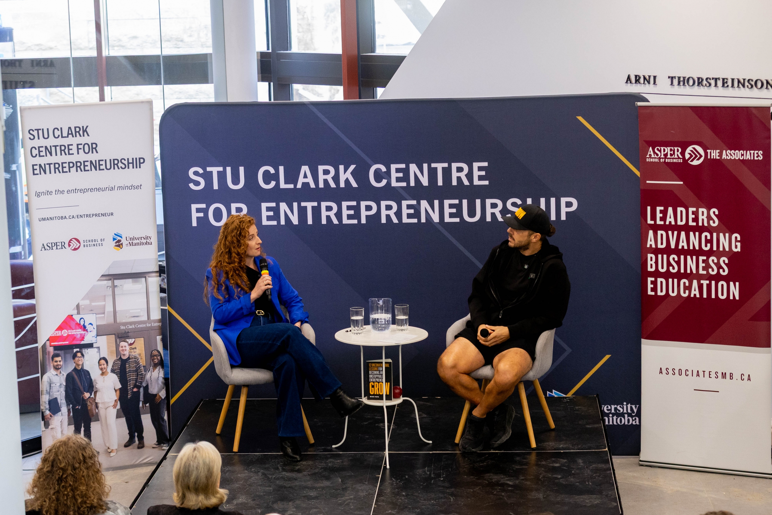 Margaux Miller and Mike Fata chat in front of a Stu Clark Centre for Entrepreneurship banner
