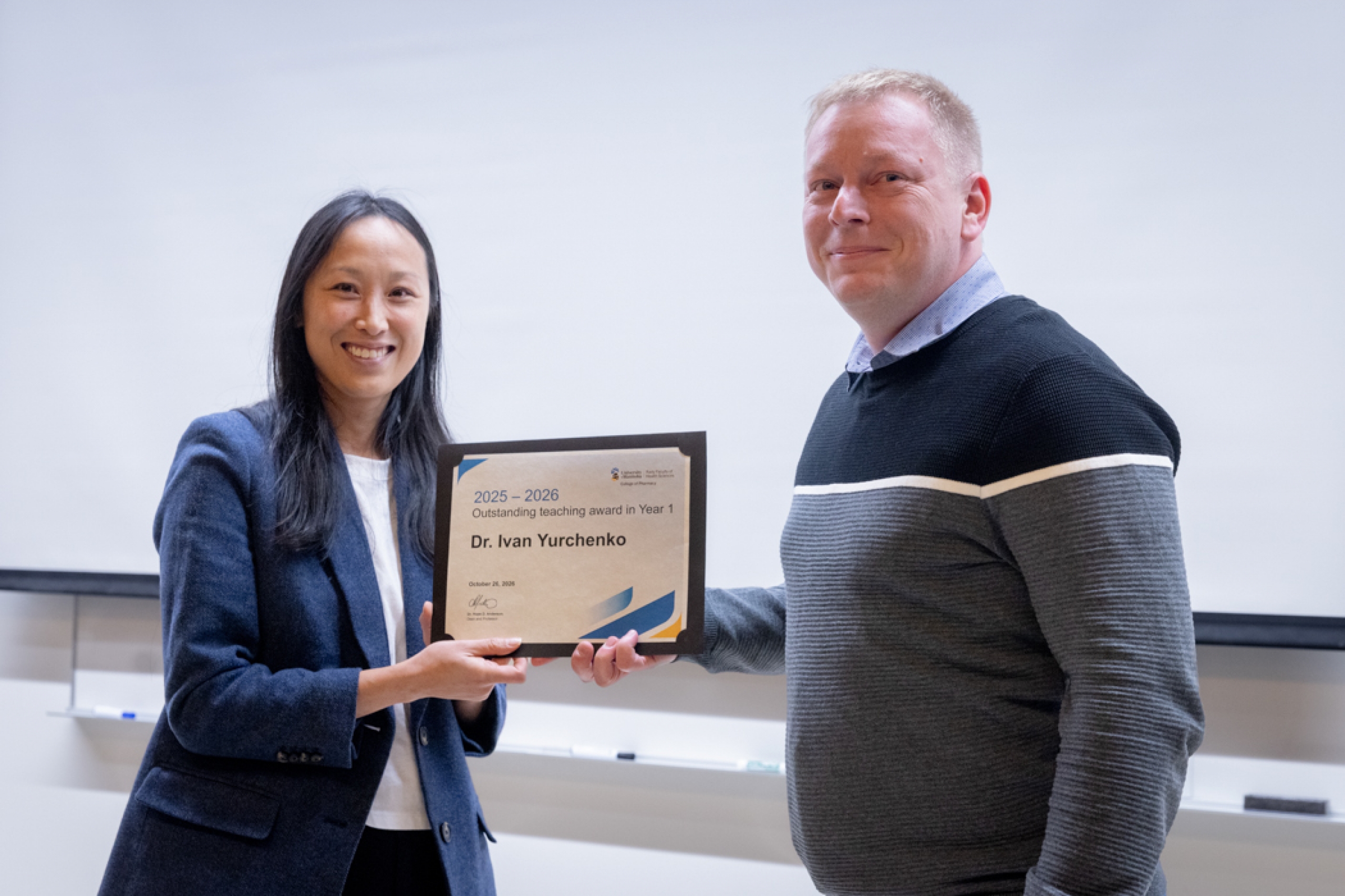 Presenter giving recipient an award.