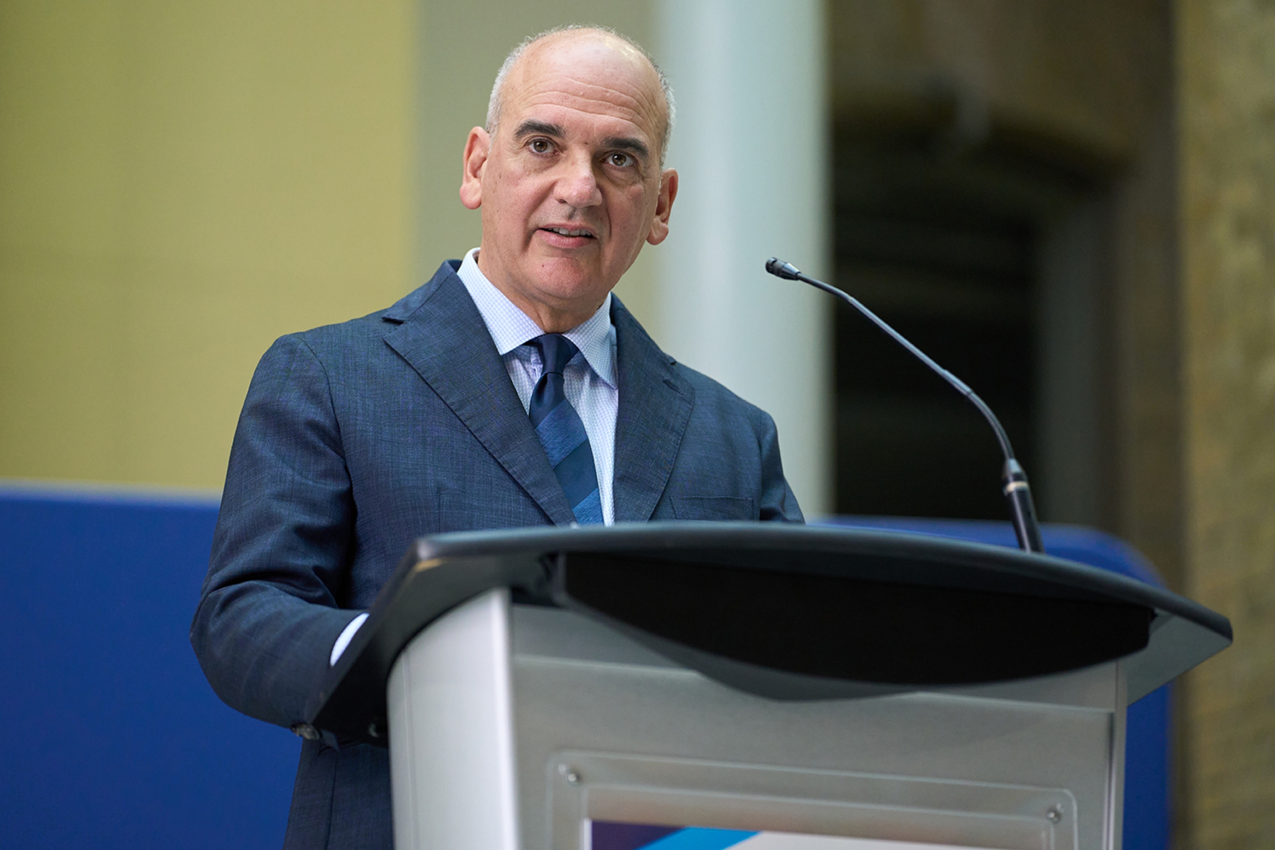 Dr. Ernest Cholakis speaking at a podium