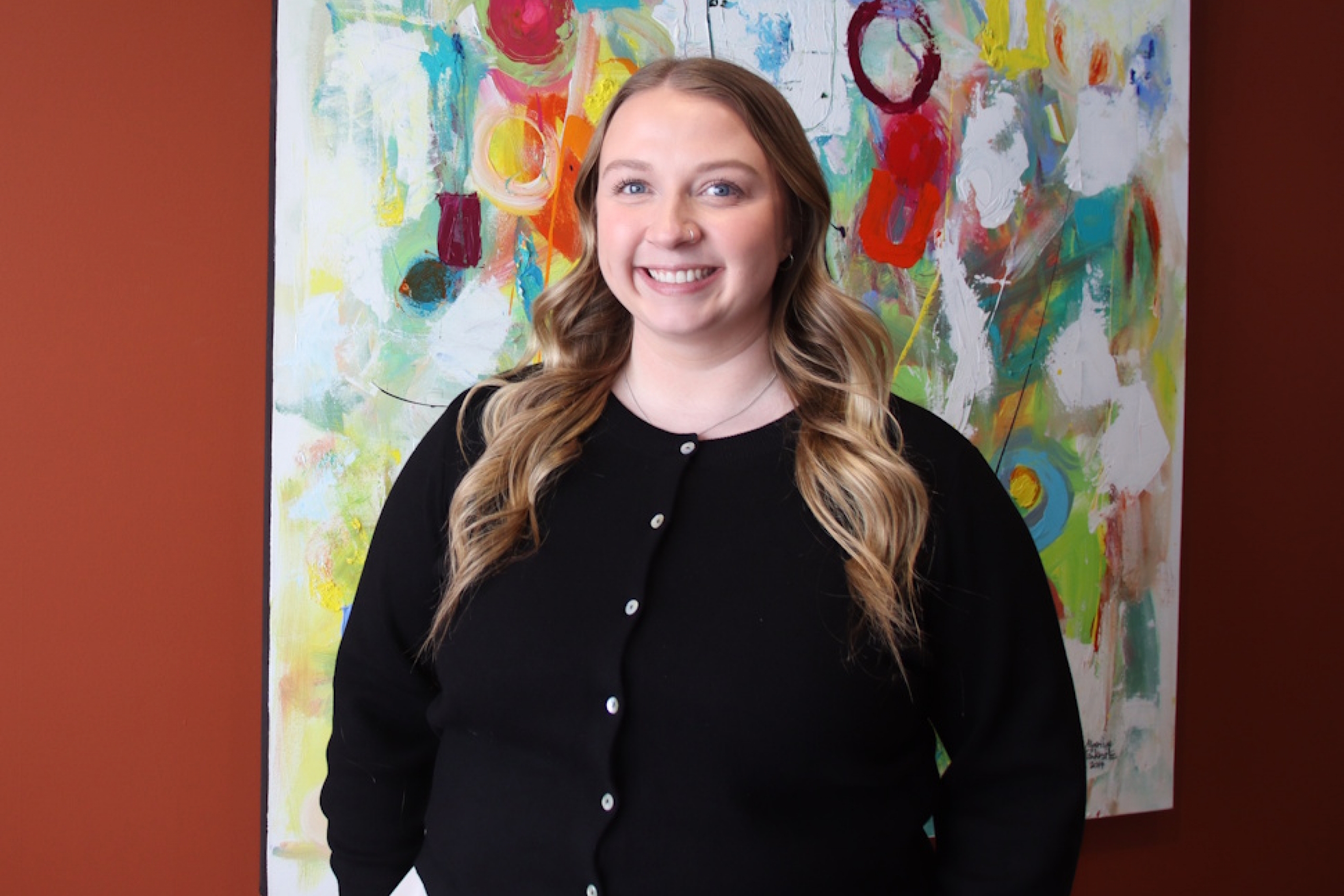 A woman smiling with art behind her