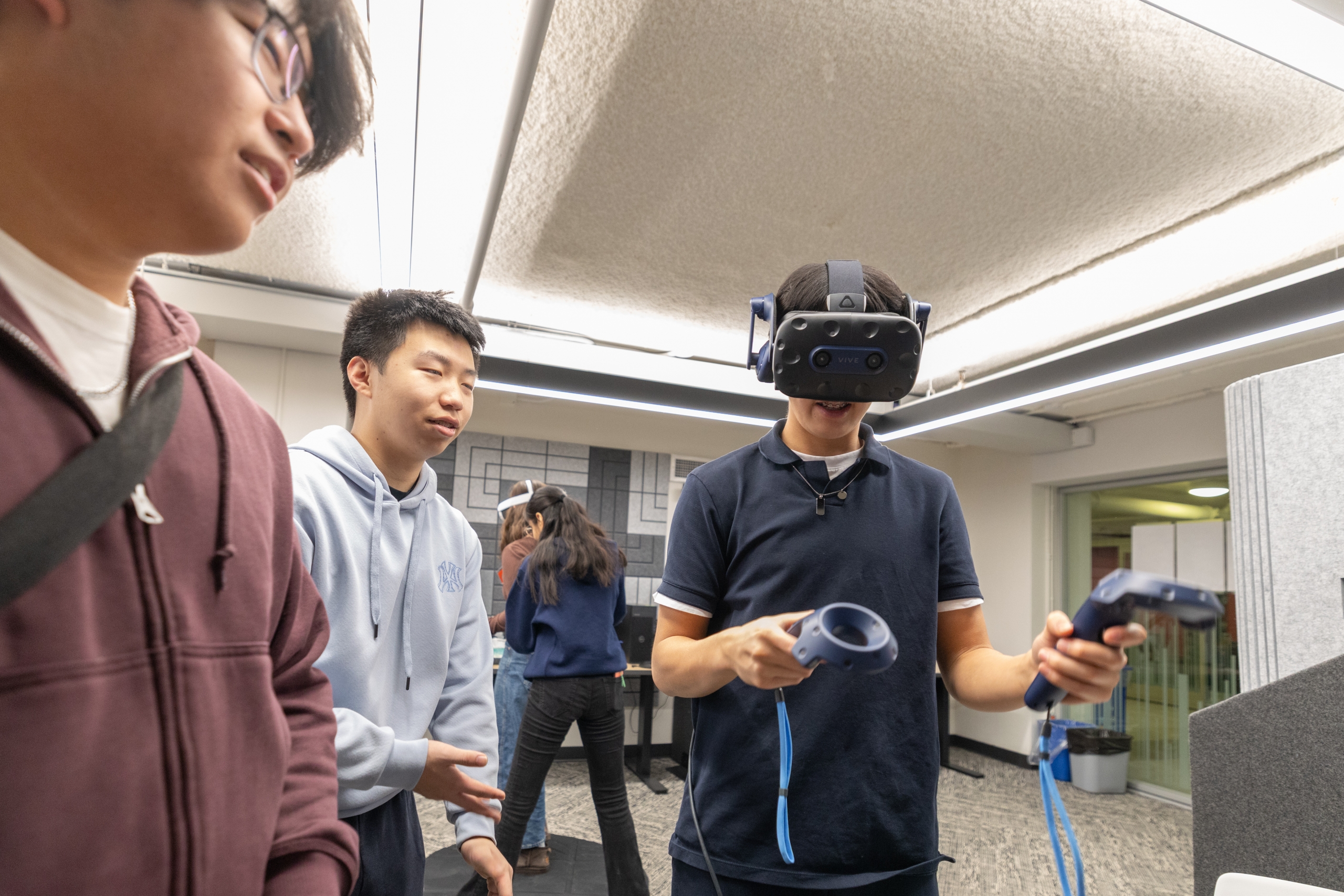 A group of young students testing out VR headsets in the lab