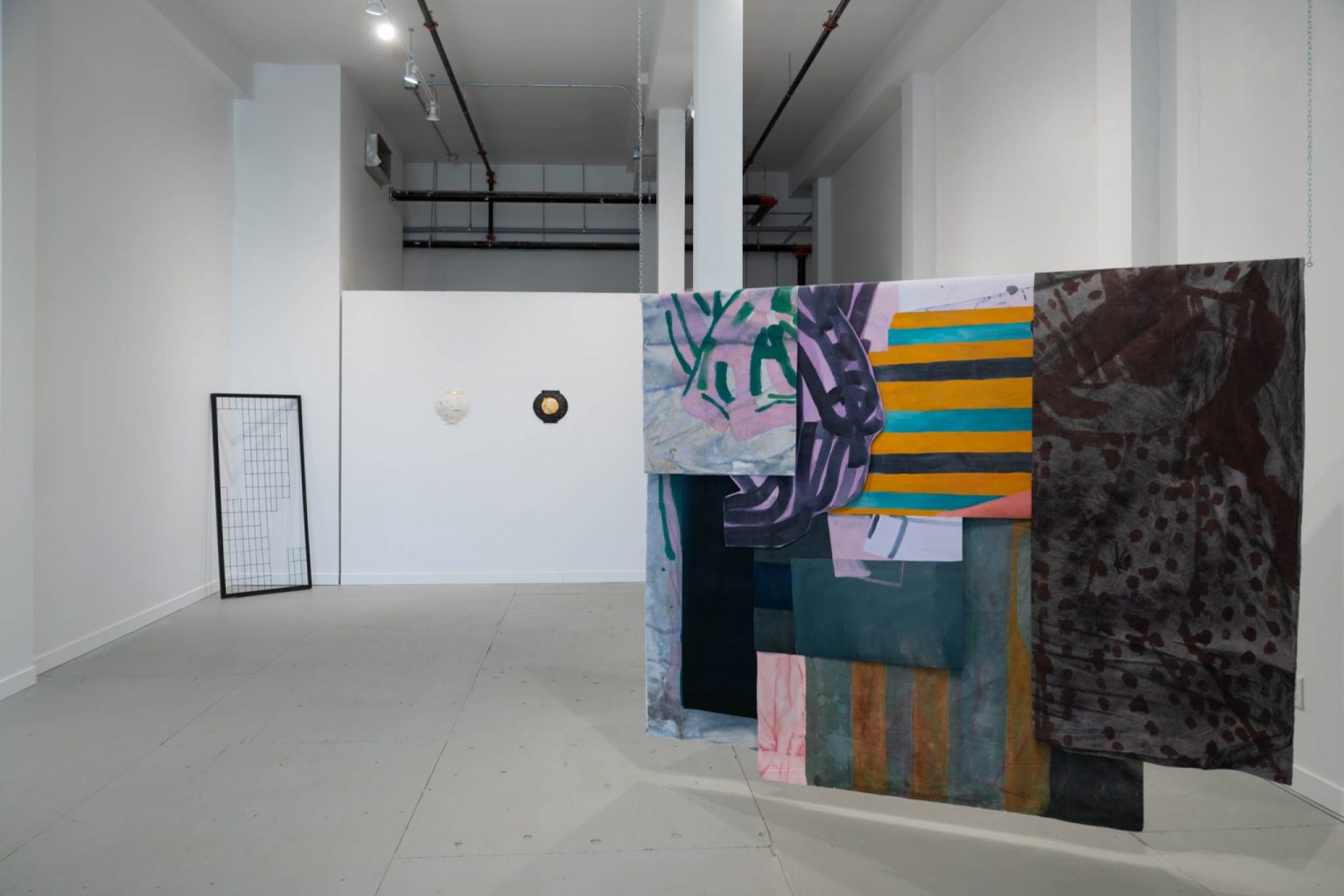 Installation view showing a large layered textile and paper work by M.E. Sparks