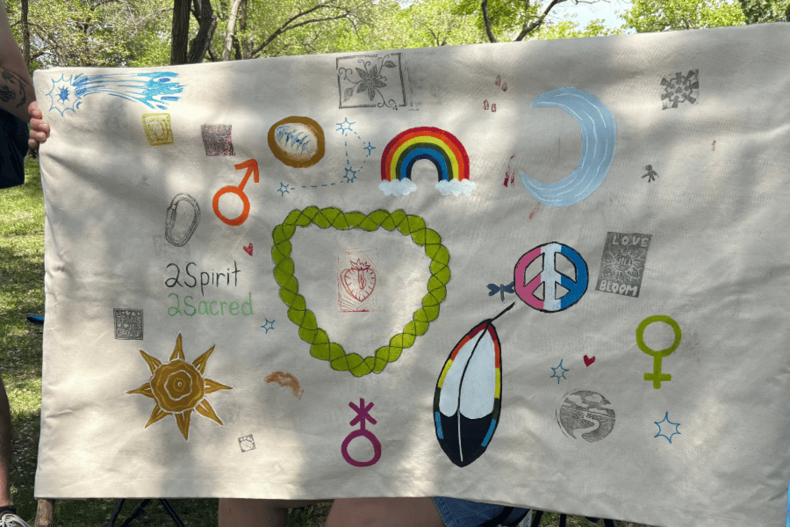 Hand-painted banner featuring Two-Spirit symbols, artwork and community teachings.