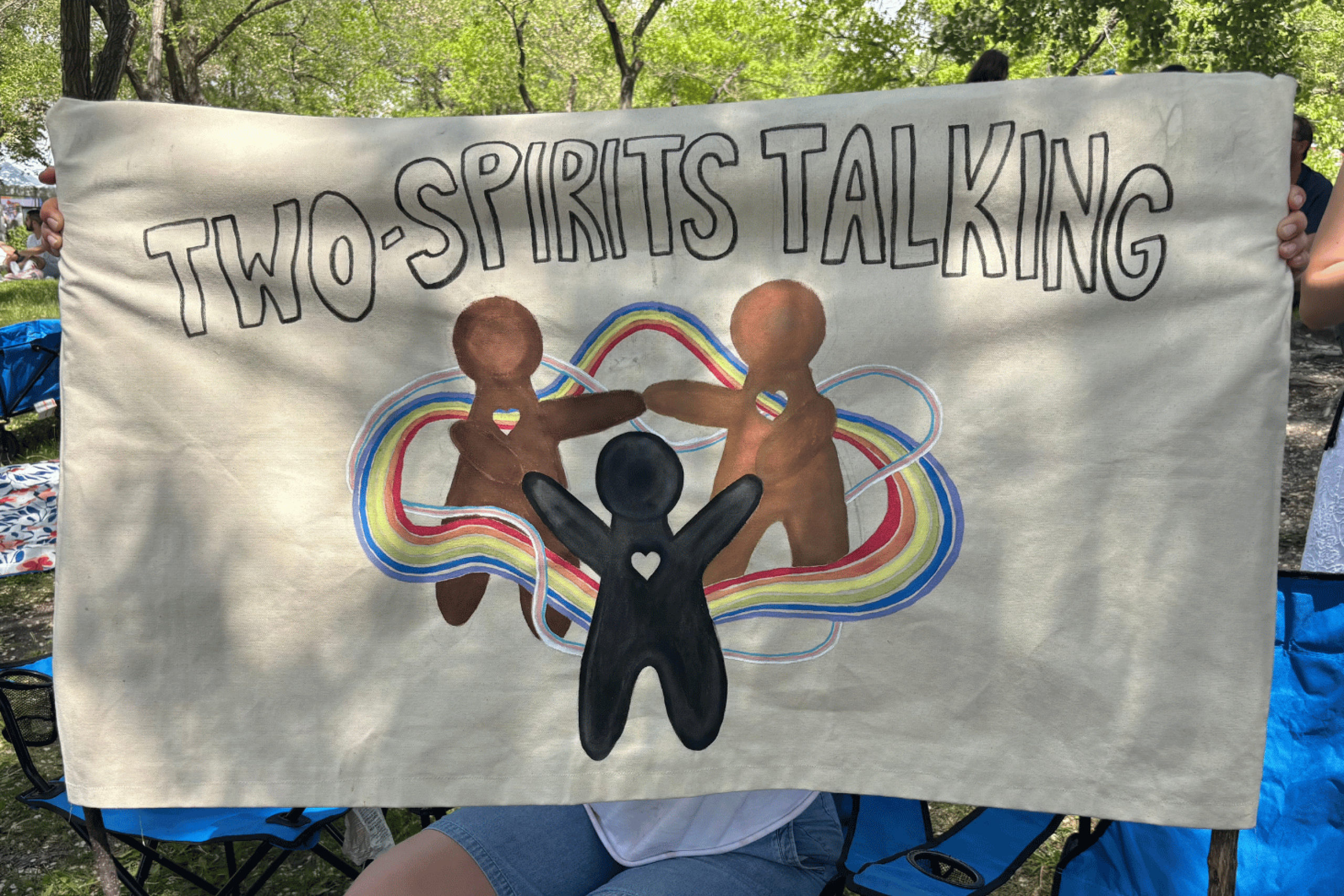 Two-Spirits Talking banner displayed at an outdoor community event.