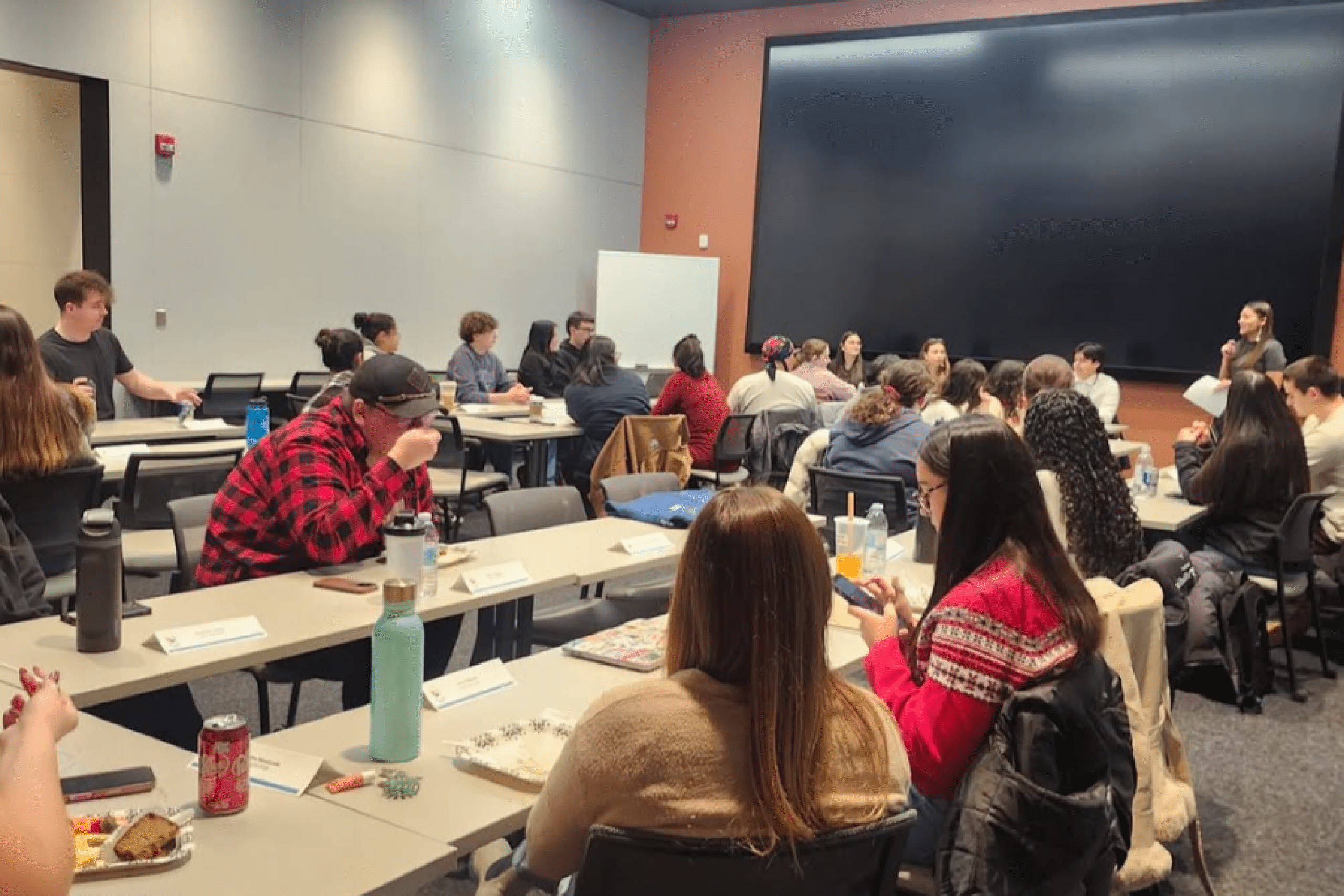 Students gathered in a classroom listening during a group session.