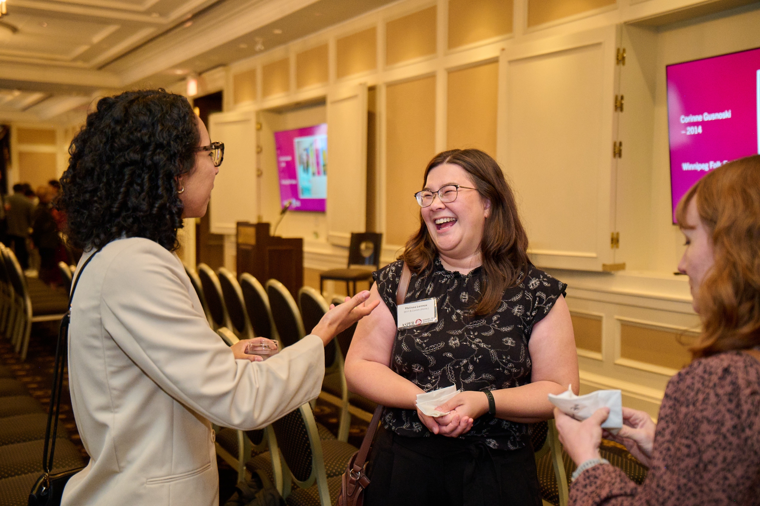 An alumni smiles in conversation