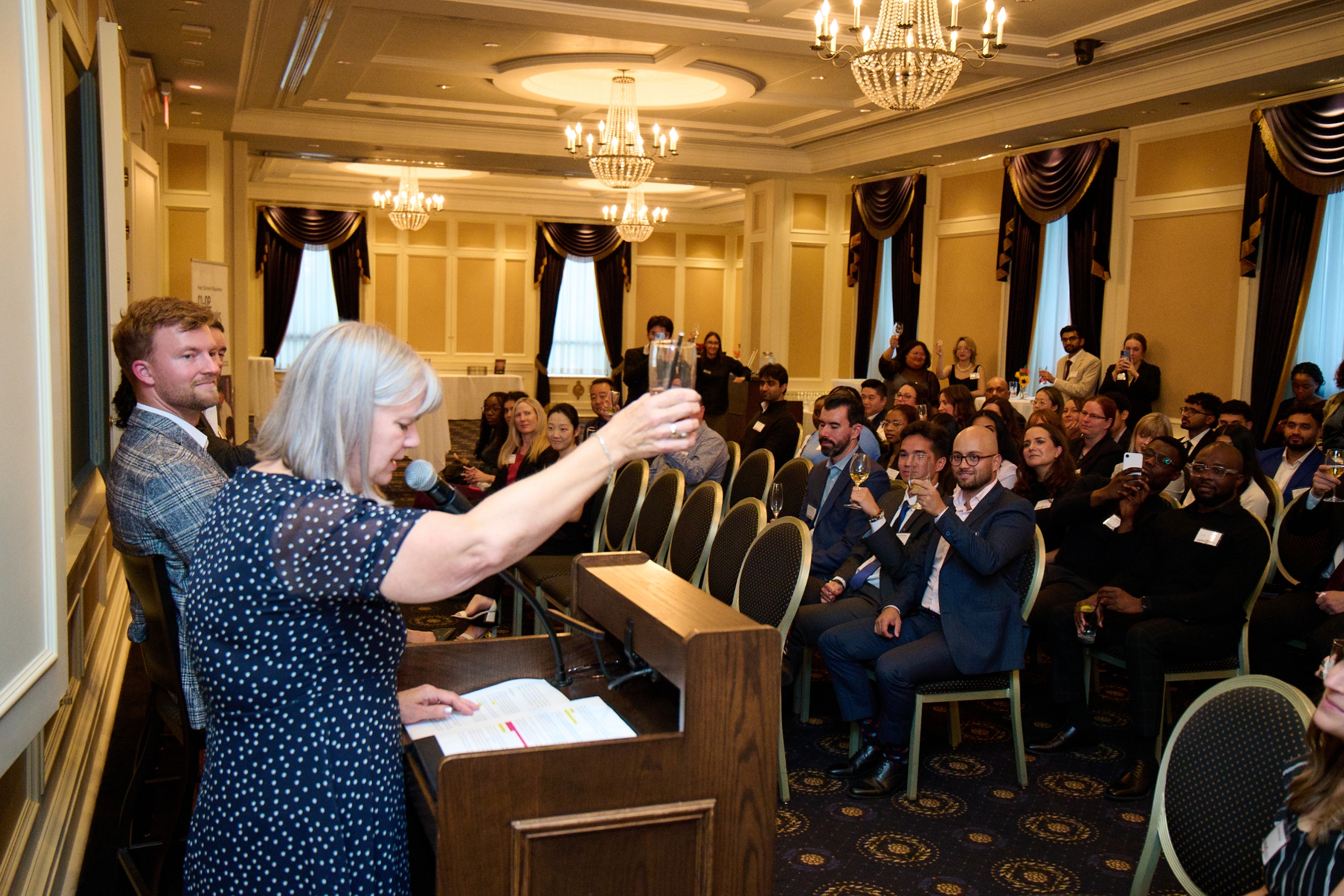 Kelly Mahoney toasts a glass at an event